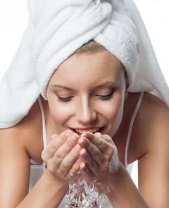 woman in towel washing her face