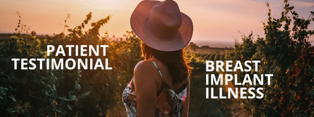 woman with a hat on standing in a field at sunset