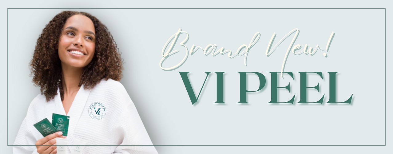 woman in white robe smiling holding VI peel treatment packages