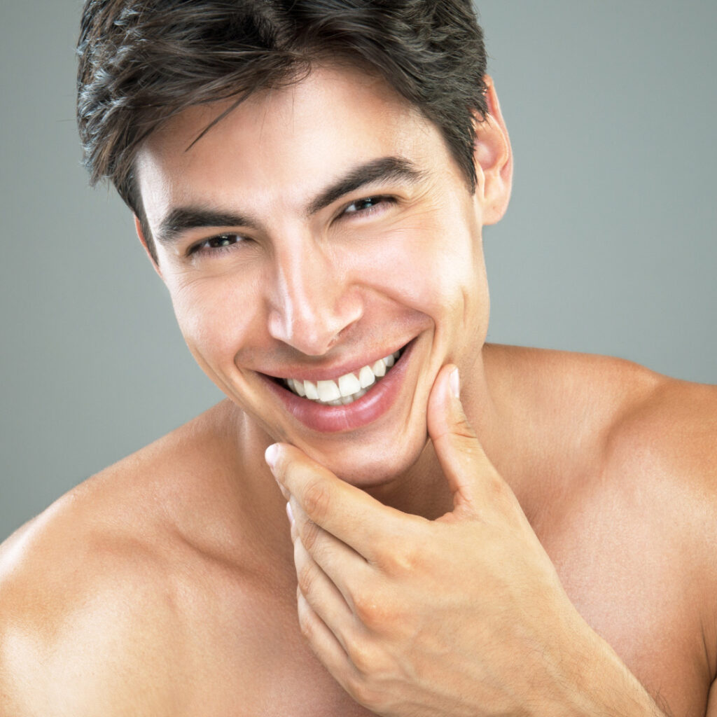 attractive male with perfect skin smiling touching chin